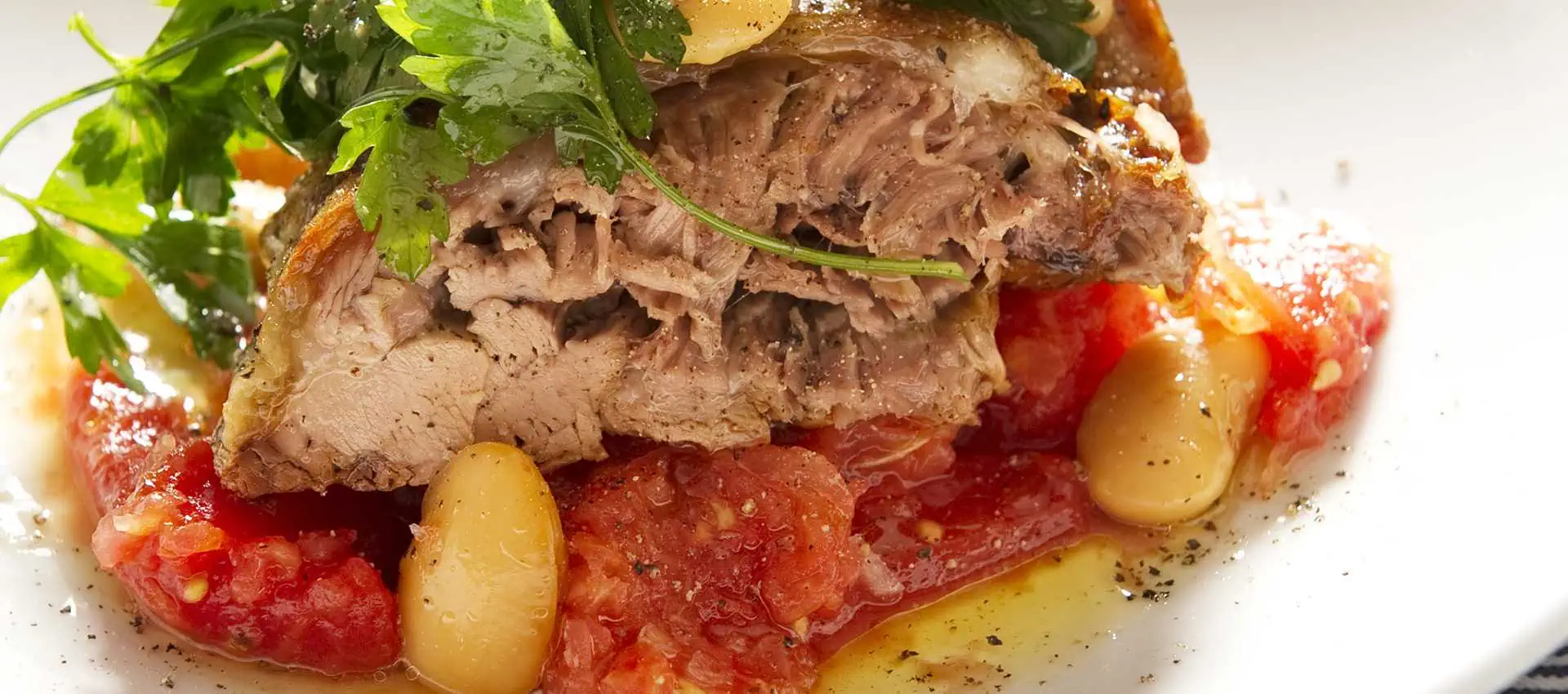 Tender leg of lambs with tomatoes, parsley and beans