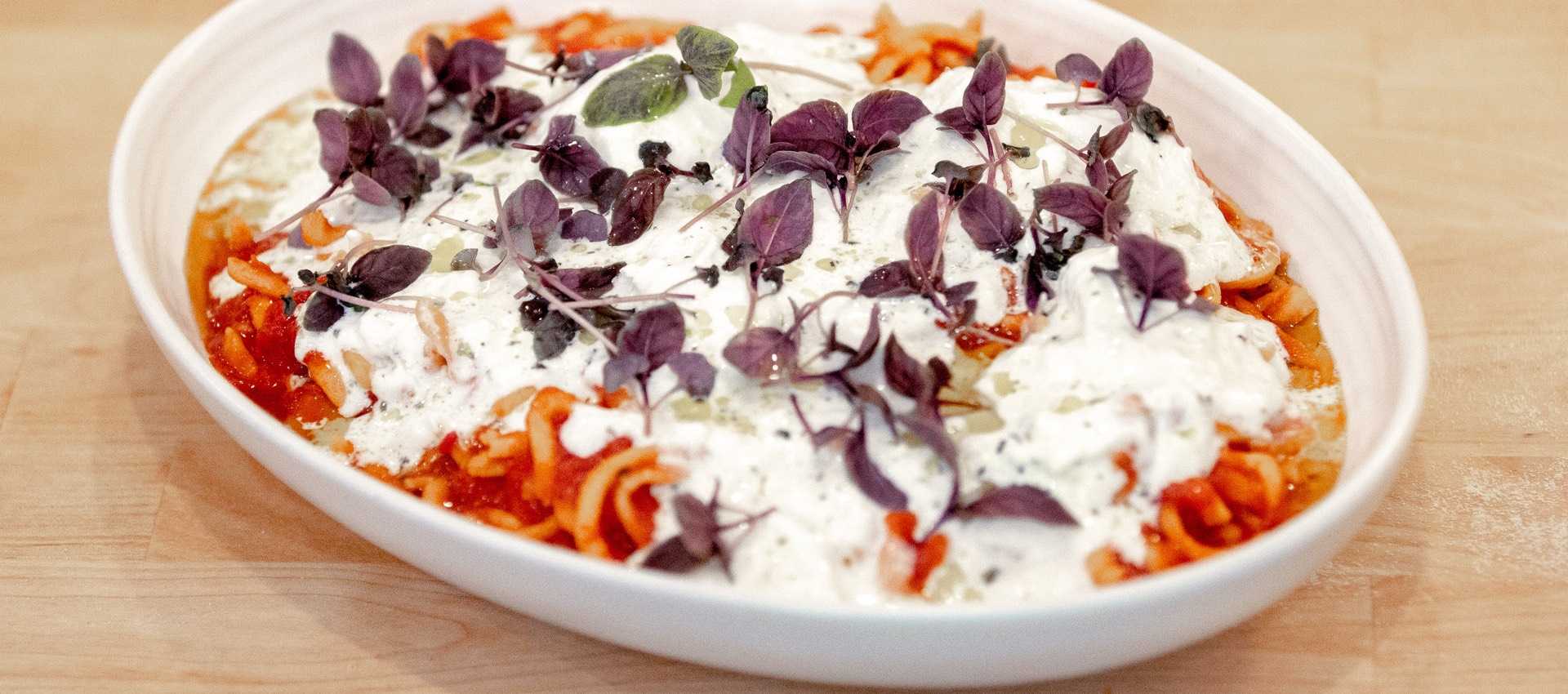 Spicy chitarra pasta with burrata, anchovy colatura, and basil