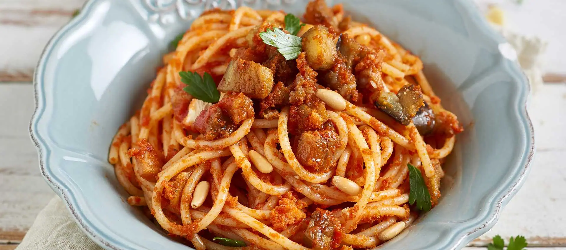 Spaghetti con melanzane pinoli e pane croccante