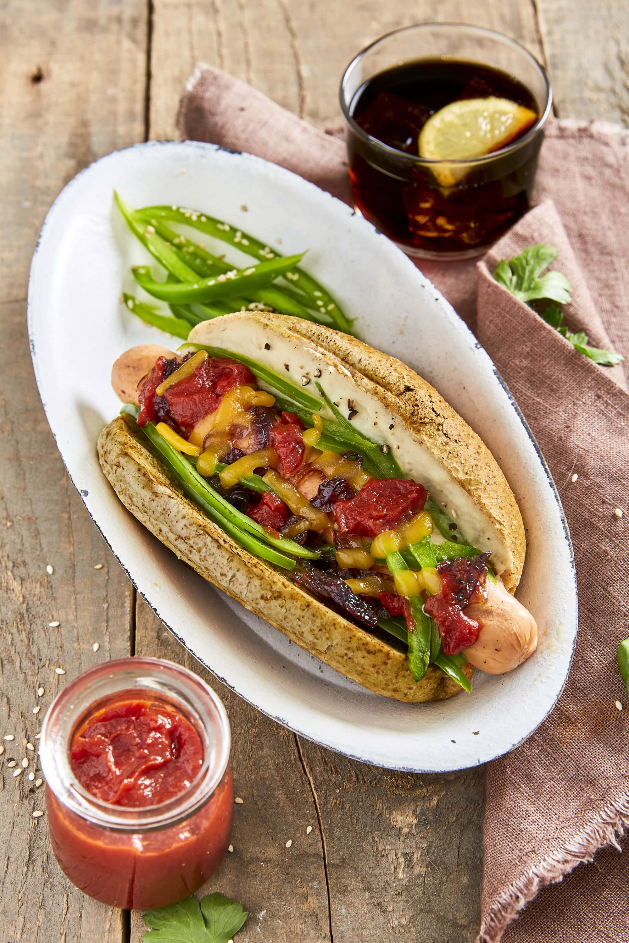 Gourmet hot dogs with cannellini sauce, sliced green pepper, caramelized red onions, shredded cheese and ketchup