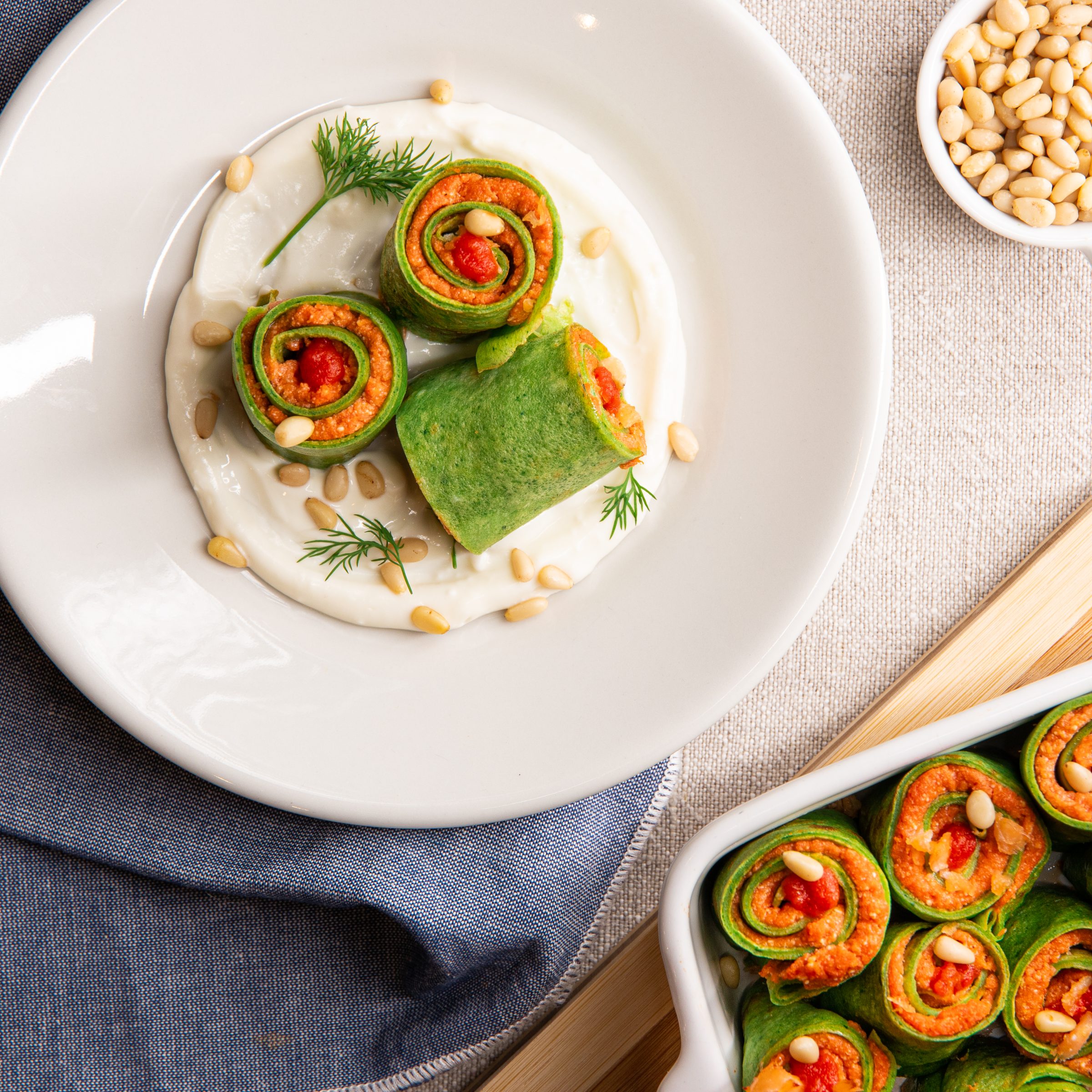 Green crepes with a salmon filling and toasted pine nuts