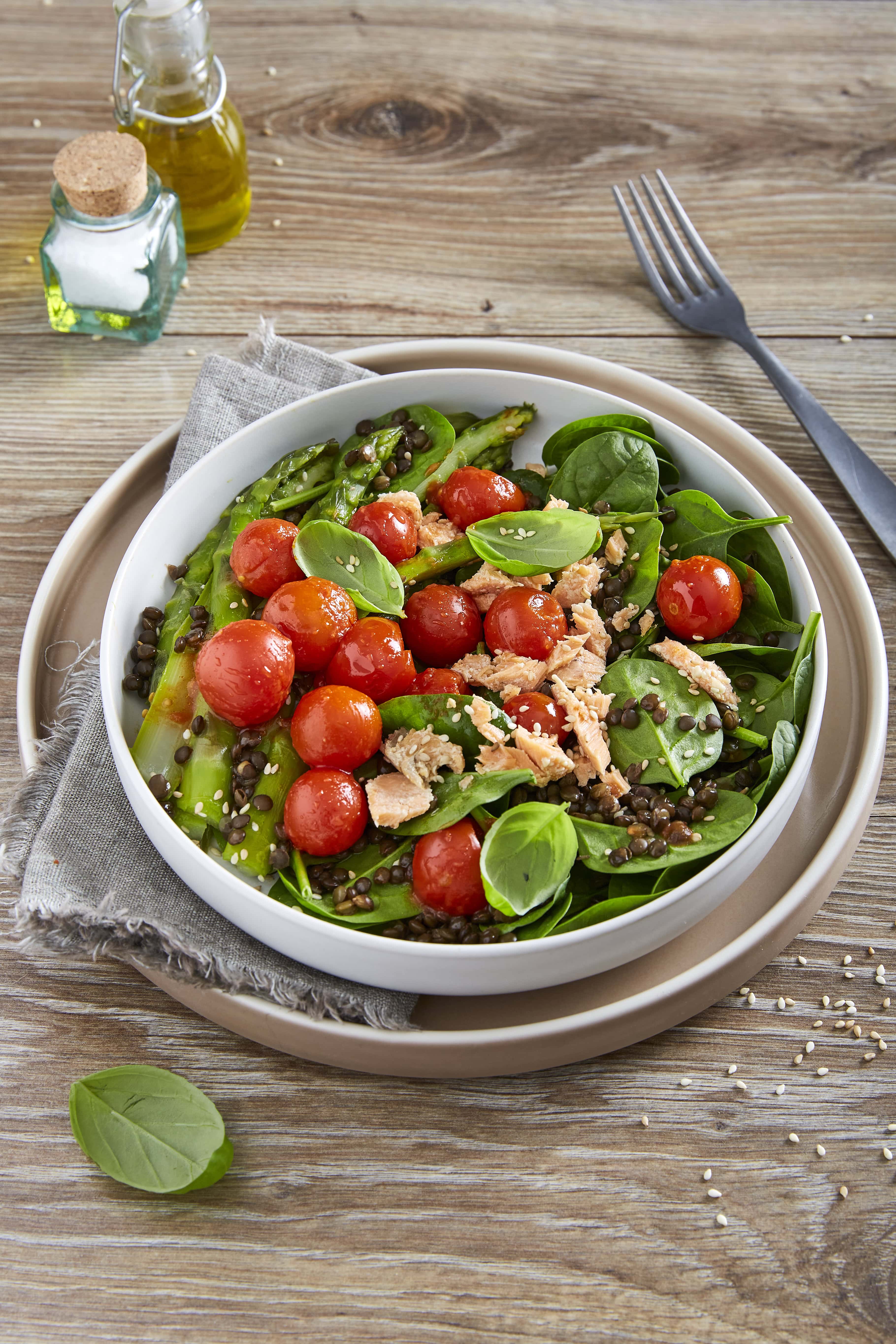 Salad with salmon, cherry tomato, black lentils and asparagus